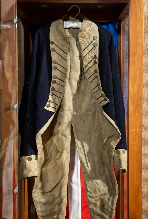 A Revolutionary War military coat on display, showing the wear and tear of years of service during America's fight for independence.